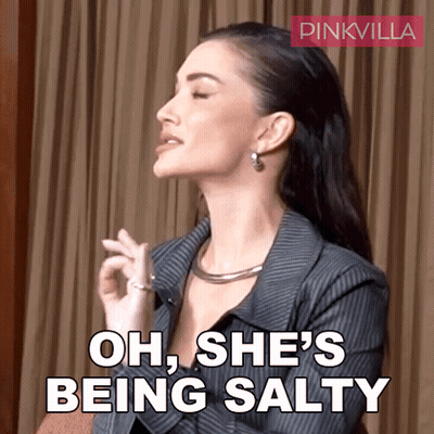 A Woman Says Oh She 'S Being Salty In Front Of A Curtain GIF