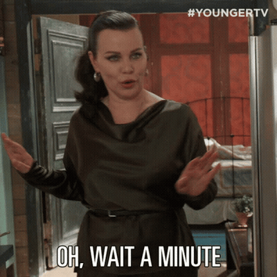 A Woman Says Oh Wait A Minute While Standing In Front Of A Door GIF