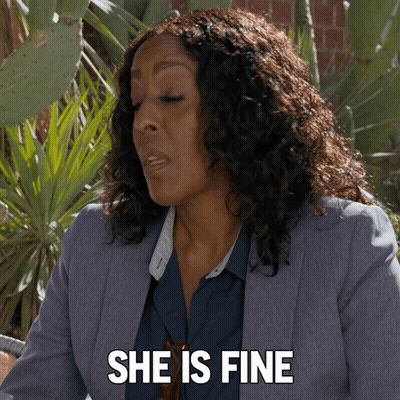 A Woman Says She Is Fine In Front Of A Plant GIF
