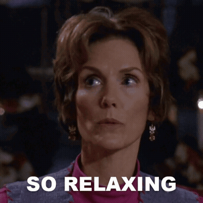A Woman Says She Is So Relaxing In Front Of A Dark Background GIF