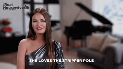 A Woman Says She Loves The Stripper Pole In Front Of A Piano And Couch GIF