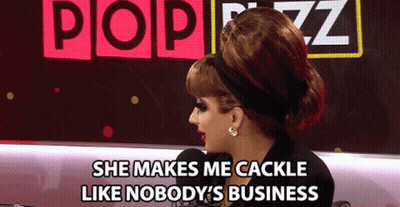 A Woman Says She Makes Me Cackle Like Nobody 'S Business In Front Of A Pop Buzz Sign GIF