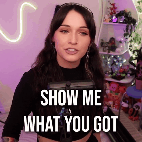 A Woman Says Show Me What You Got In Front Of A Purple Background GIF