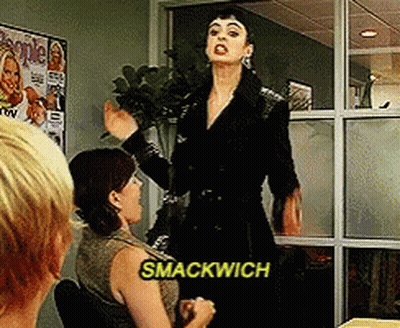 A Woman Says Smackwich While Standing In Front Of A Group Of People GIF