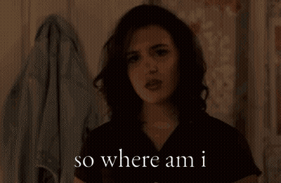 A Woman Says " So Where Am I " While Standing In Front Of A Wall GIF