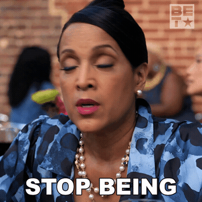 A Woman Says Stop Being While Wearing Pearls And A Blue Shirt GIF