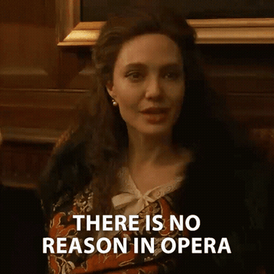A Woman Says There Is No Reason In Opera While Sitting In Front Of A Fireplace GIF