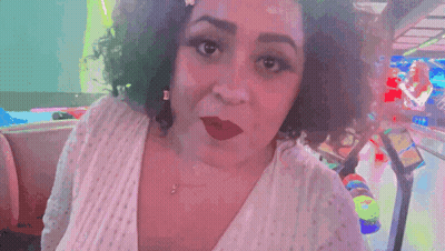 A Woman Says " U Heard Me " In Front Of A Pinball Machine GIF