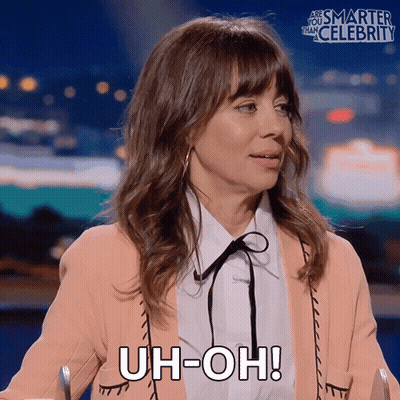 A Woman Says Uh-Oh While Sitting At A Table GIF