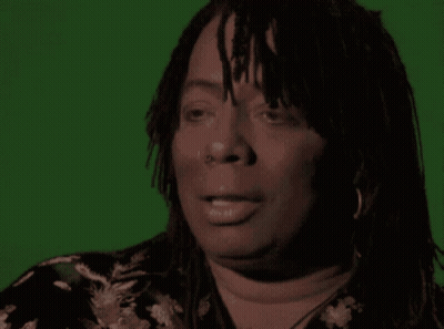 A Woman Says Vaccines Are A Hell Of A Drug In Front Of A Green Background GIF