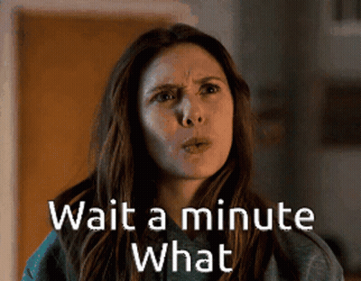 A Woman Says Wait A Minute What In Front Of A Door . GIF