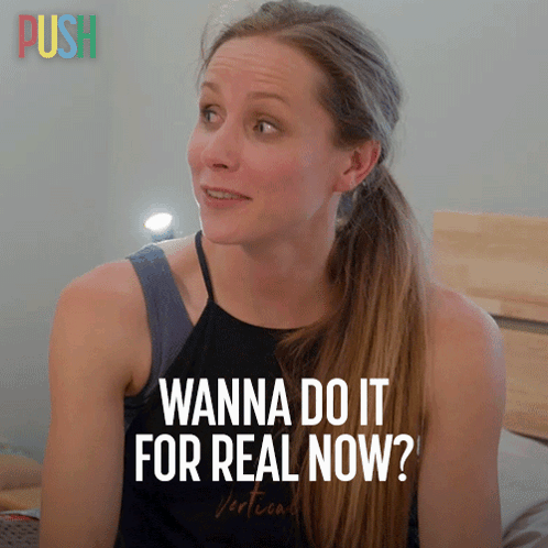 A Woman Says " Wanna Do It For Real Now " In Front Of A Sign That Says Push GIF