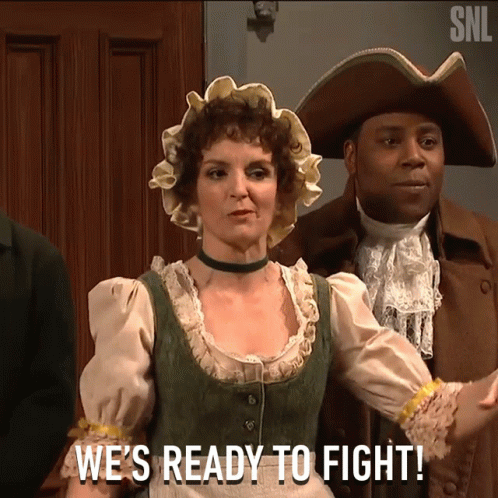 A Woman Says We 'Re Ready To Fight In Front Of A Man In A Pirate Hat GIF
