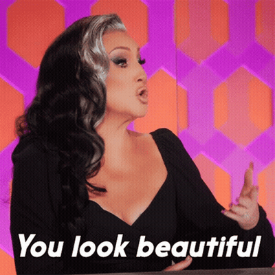 A Woman Says " You Look Beautiful " In Front Of A Purple And Orange Background GIF