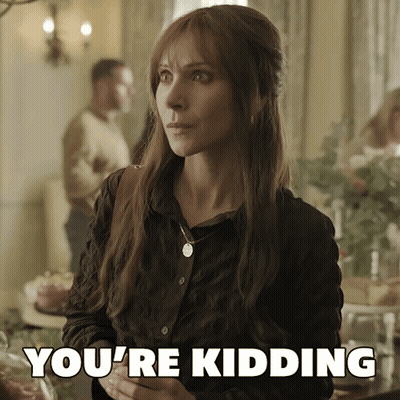 A Woman Says You 'Re Kidding While Standing In Front Of A Table GIF
