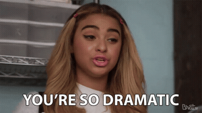 A Woman Says " You 'Re So Dramatic " In Front Of A Rack GIF