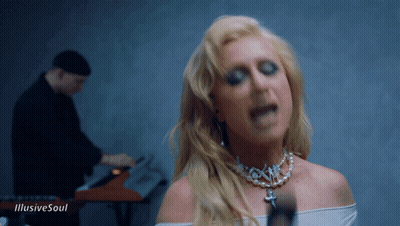 A Woman Singing In Front Of A Man Playing A Keyboard With The Words " Illusive Soul " On The Bottom GIF