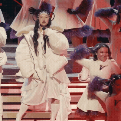 A Woman Singing Into A Microphone On Stage GIF