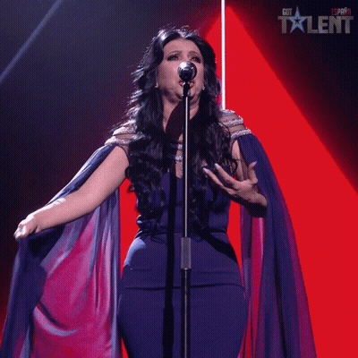 a woman singing into a microphone with a red background that says got talent on it