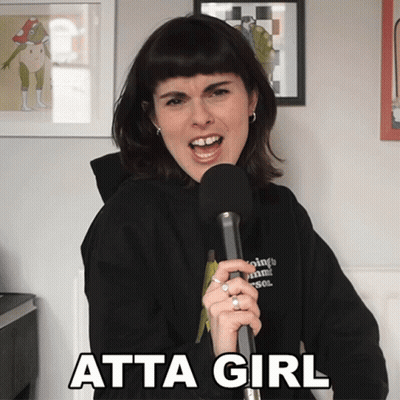 A Woman Singing Into A Microphone With Atta Girl Written On The Bottom Right GIF