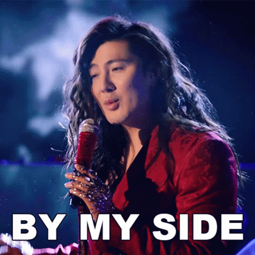 A Woman Singing Into A Microphone With By My Side Written Below Her GIF
