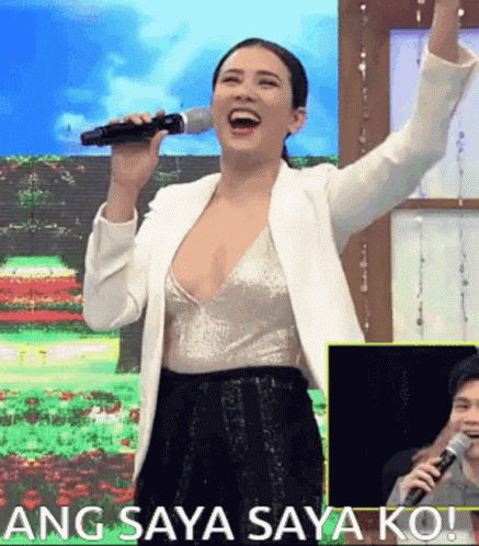 A Woman Singing Into A Microphone With The Words Ang Saya Saya Ko On The Bottom GIF