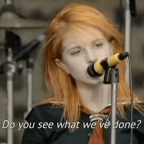 A Woman Singing Into A Microphone With The Words `` Do You See What We 'Ve Done '' Written Below Her . GIF