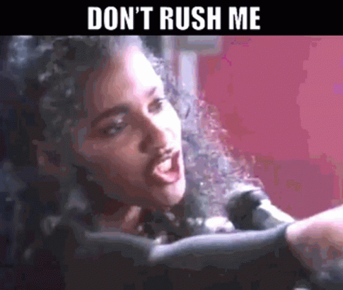 A Woman Singing Into A Microphone With The Words " Don 'T Rush Me " Above Her GIF
