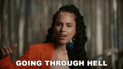 A Woman Singing Into A Microphone With The Words Going Through Hell Written Below Her GIF