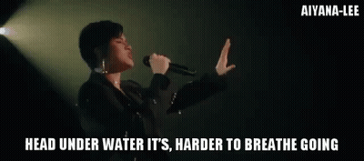 A Woman Singing Into A Microphone With The Words " Head Under Water It 'S Harder To Breathe Going " GIF
