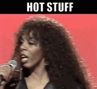 A Woman Singing Into A Microphone With The Words Hot Stuff Written Above Her GIF