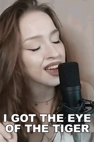 A Woman Singing Into A Microphone With The Words `` I Got The Eye Of The Tiger '' GIF