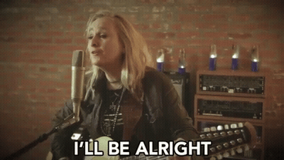 A Woman Singing Into A Microphone With The Words " I 'Ll Be Alright " Next To Her GIF
