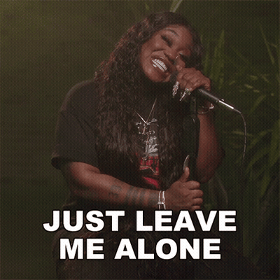 A Woman Singing Into A Microphone With The Words Just Leave Me Alone Written Below Her GIF