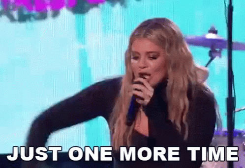 A Woman Singing Into A Microphone With The Words Just One More Time Behind Her GIF