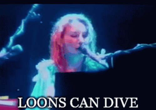 A Woman Singing Into A Microphone With The Words " Loons Can Dive " Above Her GIF