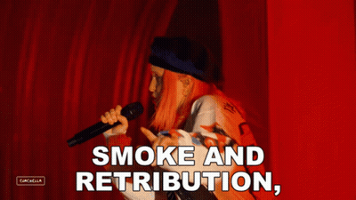 A Woman Singing Into A Microphone With The Words " Smoke And Retribution " Above Her GIF