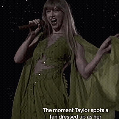A Woman Singing Into A Microphone With The Words " The Moment Taylor Spots A Fan Dressed Up As Her " GIF