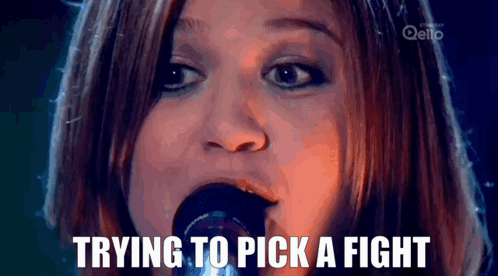 A Woman Singing Into A Microphone With The Words " Trying To Pick A Fight " Above Her GIF