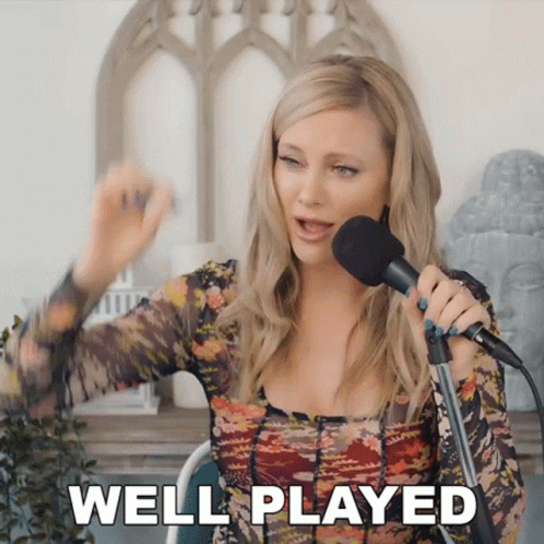 A Woman Singing Into A Microphone With The Words Well Played Written On The Bottom GIF