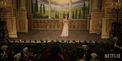 A Woman Singing On A Stage With Netflix Written On The Bottom GIF
