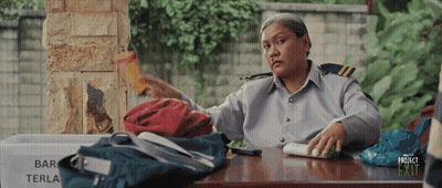 A Woman Sits At A Desk With A Sign That Says Bar Terla GIF