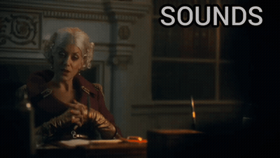 A Woman Sits At A Desk With The Words " Sounds Ridiculous But Go On " Below Her GIF