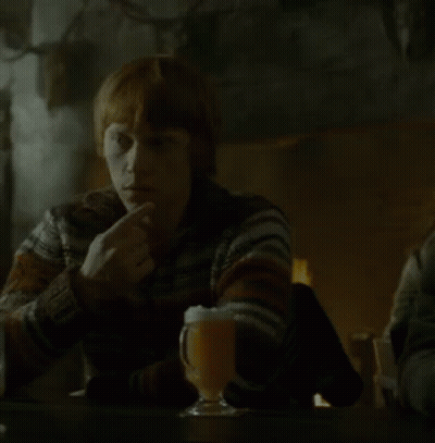 A Woman Sits At A Table With A Glass Of Beer GIF