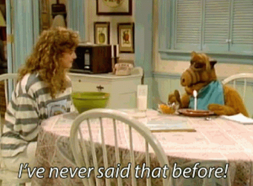 A Woman Sits At A Table With A Stuffed Animal That Says " I 'Ve Never Said That Before " GIF