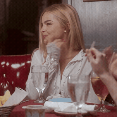 A Woman Sits At A Table With Glasses Of Water GIF