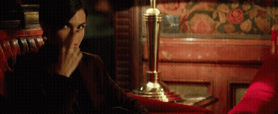 A Woman Sits In A Red Chair Covering Her Face GIF