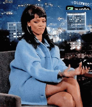 A Woman Sits In Front Of A Hollywood Sign GIF