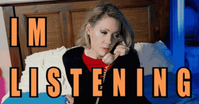 A Woman Sits On A Bed Talking On A Phone With The Words " I 'M Listening " Written Above Her GIF