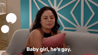 A Woman Sits On A Couch With A Pillow And Says " Baby Girl He 'S Gay " GIF